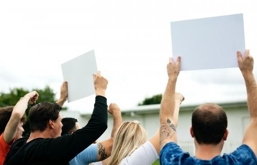 Rear view of activists showing papers while protesting - 525608