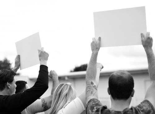 Rear view of activists showing papers while protesting - 525632