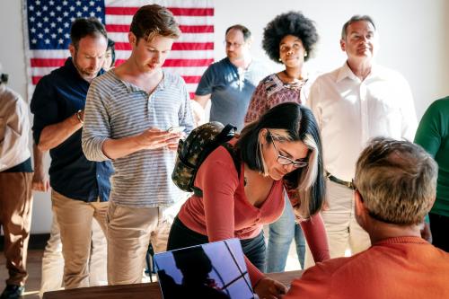 Diverse people queuing at a polling place - 2027346