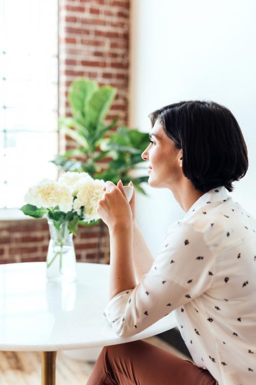 Woman sipping coffee at a cafe - 2030371