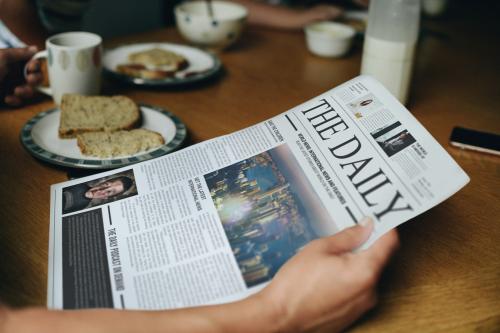 Man reading the news at the breakfast table - 527239
