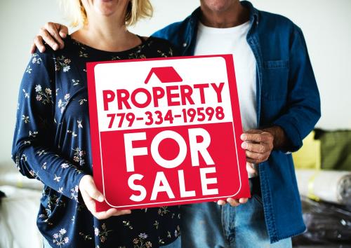 Couple with a property for sale sign - 527910