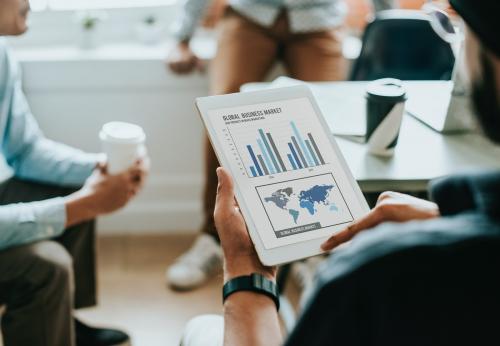 Businessman showing a tablet with global business market chart - 534166