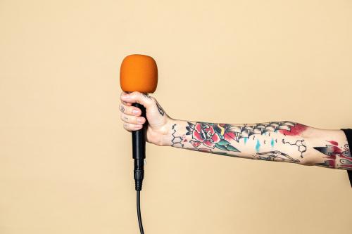 Hand with tattooed holding a microphone - 2056067