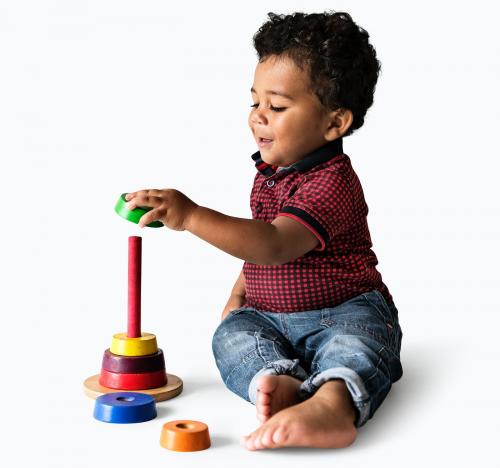 Happy boy enjoying stacking colorful discs - 536024