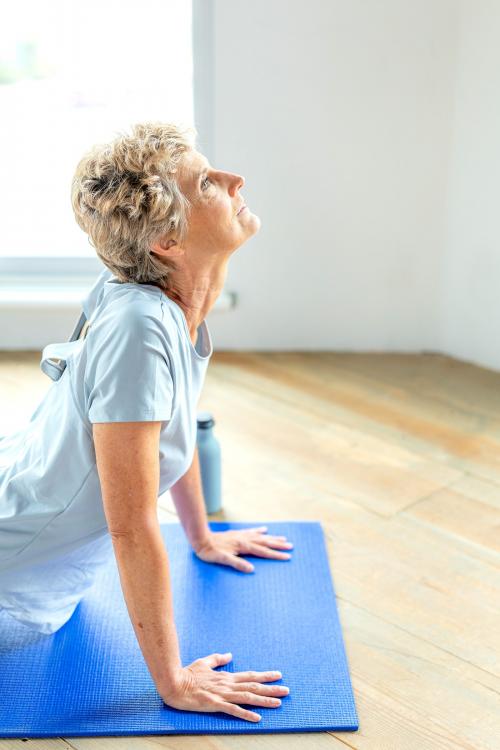 Senior woman doing a Bhujangasana pose - 2110287