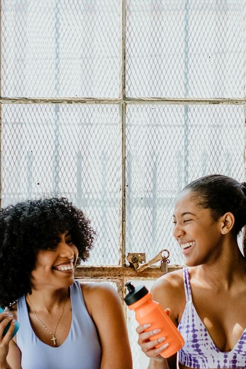 Sportive women talking in a gym while drinking water - 2110447