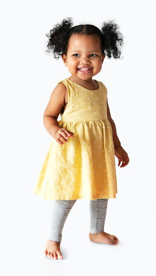 Happy little girl in a yellow dress standing - 536101