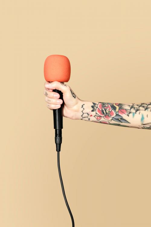 Hand holding a microphone with cream background - 2050926