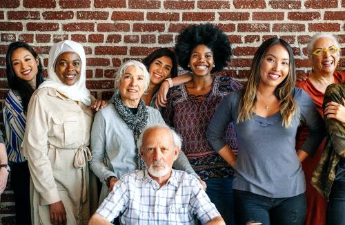 Group of diverse people standing in front of a brick wall - 2027364