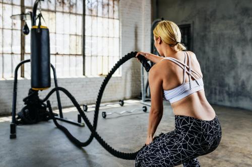 Sportive woman working out on the battle ropes - 2109034