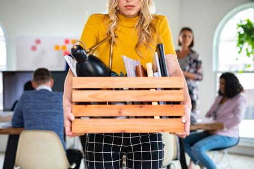 Young businesswoman carrying a wooden box - 2204073