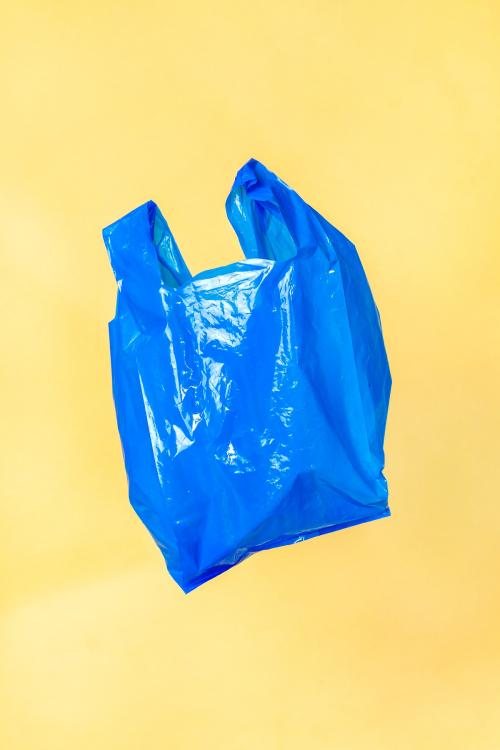 Blue plastic bag floating with a yellow wall - 2051015