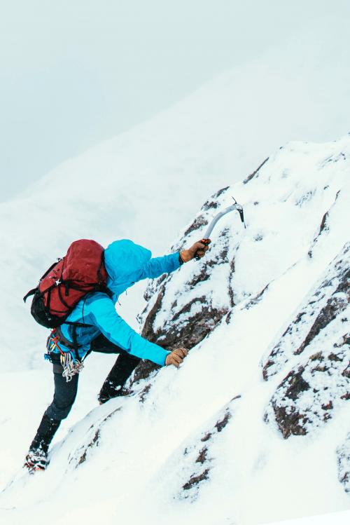 Mountaineer using an ice axe to climb Forcan Ridge in Glen Shiel, Scotland - 2221708
