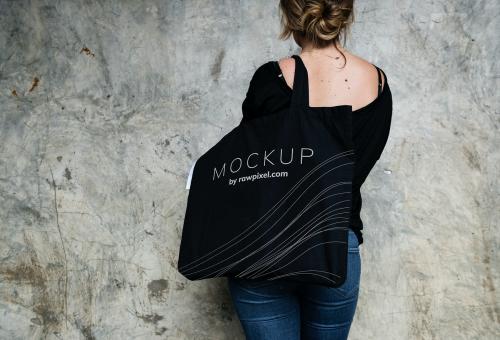 Woman carrying a black tote bag mockup - 502870