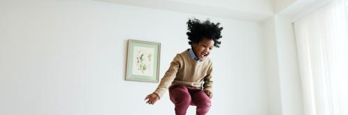 Young happy kid having fun jumping up and down on a bed social banner - 2025142