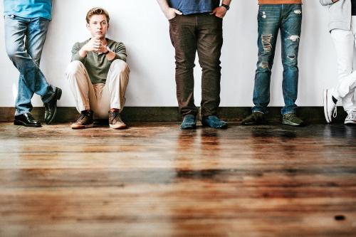 Tired boy sitting on a wooden floor - 2027407