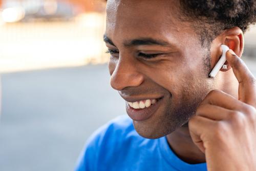 Man listening to music by wireless earphones - 2041651