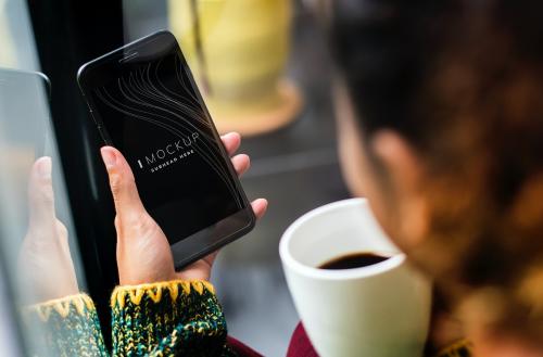 Woman using a mobile phone mockup in a coffee shop - 503001