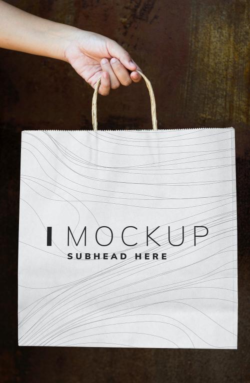 Female hand holding a paper bag mockup - 503018