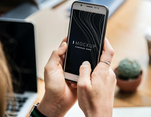 Woman using a mobile phone mockup in an office - 503019