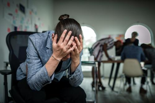 A stressed businessman sitting on a chair in an office - 2204588