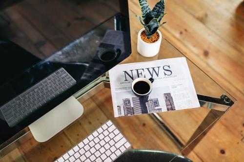 Laptop and a newspaper on a desk - 2205372