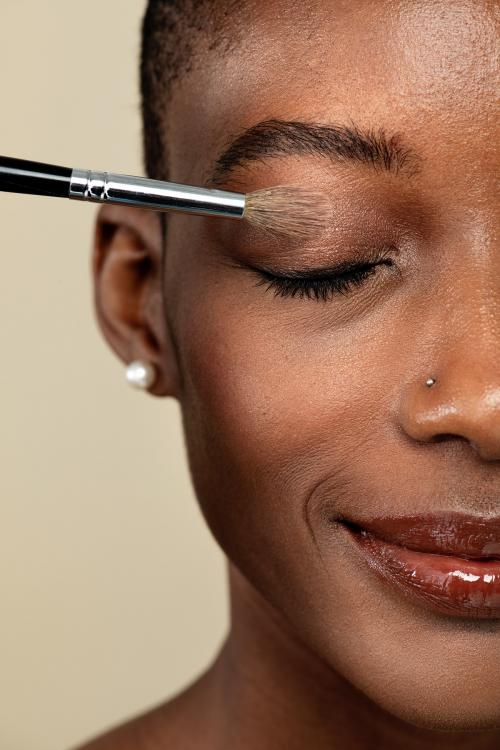 Makeup artist applying eye shadow on a black woman - 2250000