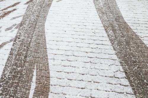 Skid marks on a an icy cobblestone road background - 2255786