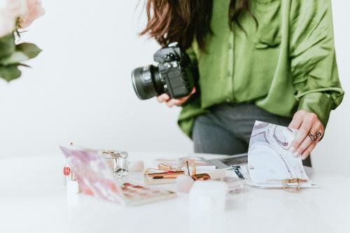 Female photographer shooting beauty products on the table - 2030414