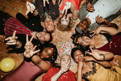 Friends lying on the floor at a party with balloons - 2097429