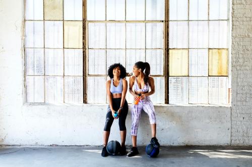 Sportive women talking in a gym while drinking water - 2107396