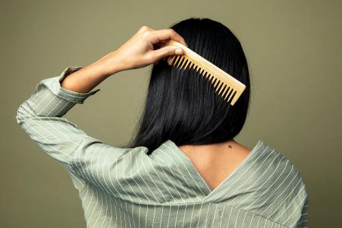 Rear view of a woman combing her hair - 2210588