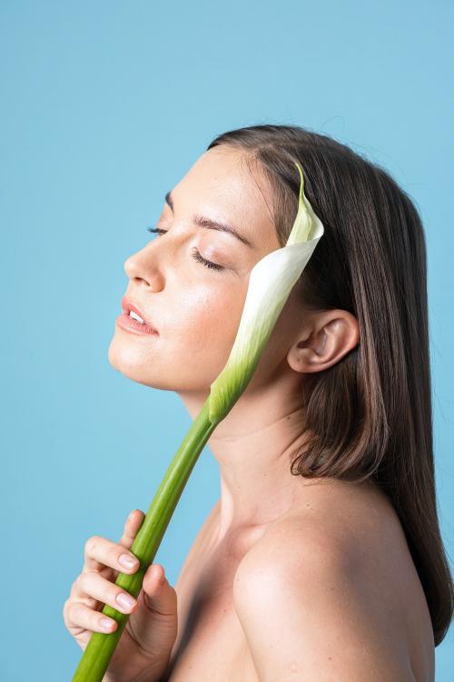 Portrait of a woman with a white lily on blue background - 2230493