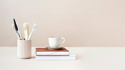 Paintbrushes and cup on top of books - 2259528