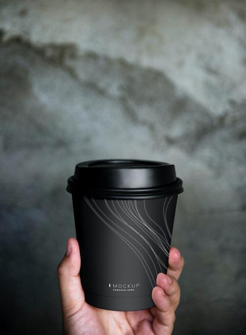 Human hand holding a mockup coffee cup - 502838