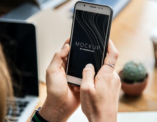 Woman using a mobile phone mockup in an office - 502861