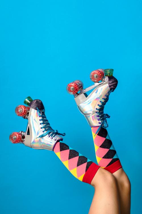 Feminine legs in a roller skates shoes with blue background - 2051888