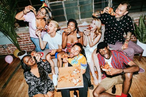 A group of diverse friends enjoying pizza at a party - 2097392