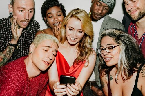 Diverse group of friends checking out a cute photo - 2097466