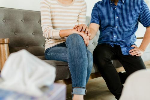 Couple holding hands sitting on a sofa - 2194600