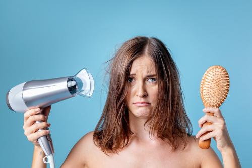 Woman blow drying her messy hair - 2230358