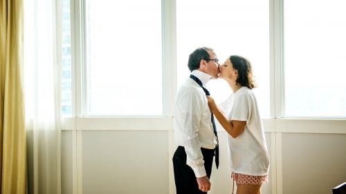 Woman kissing husband while dressing up - 2024944