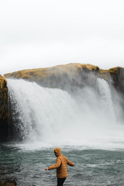 Man by the waterfall walking on rocks - 2047626