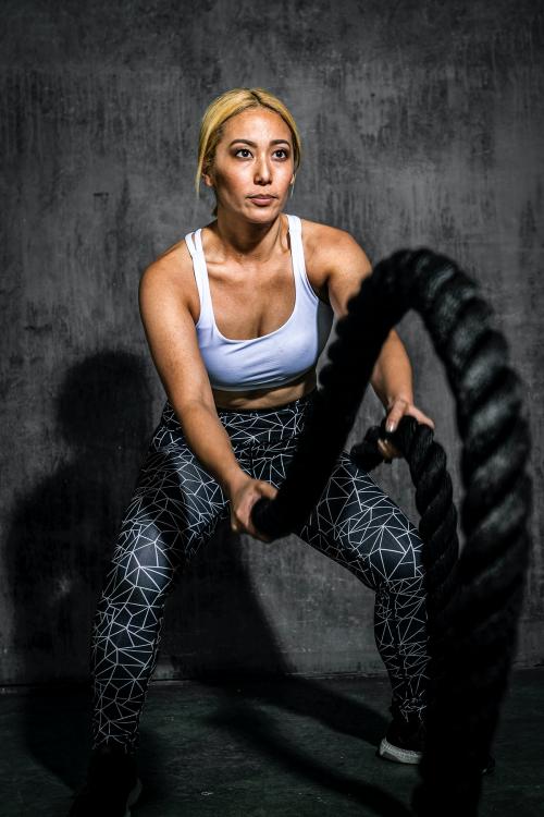 Sportive woman working out on the battle ropes - 2107382