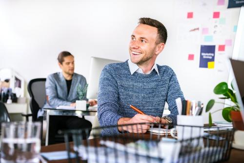 Happy businessman taking notes in the office - 2204586