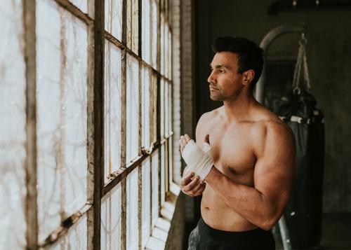 Male boxer putting a strap on his hand - 2107331