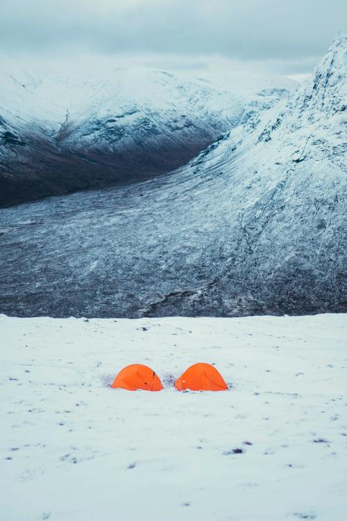 Orange tents at a snowy mountain - 2221577