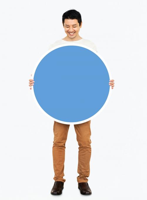 Cheerful man holding a blank blue circle - 490948