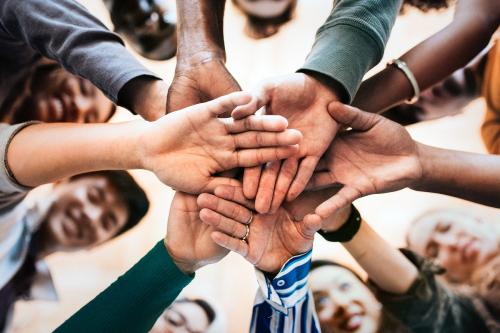 Group of diverse people stacking hands in the middle - 2027146